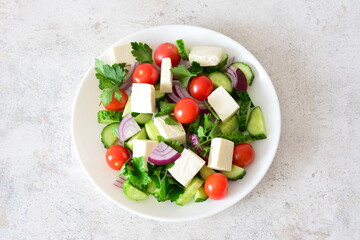 Fresh and Healthy Greek Salad with Feta Cheese on a White Plate isolated no olives