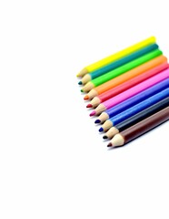 A vibrant array of sharpened color pencils neatly aligned on a white surface, symbolizing creativity, learning, and artistic expression.