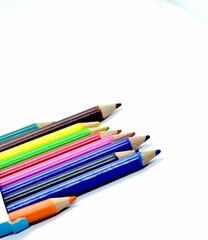 An out of box array of sharpened color pencils randomly aligned on a white surface, symbolizing creativity, learning, and artistic expression.