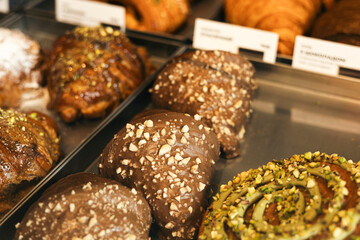 Chocolate croissants with nuts on cafe display counter, bakery pastry.