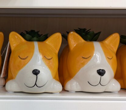 Maceteros de cer&aacute;mica con forma de perro, en estante de comercio