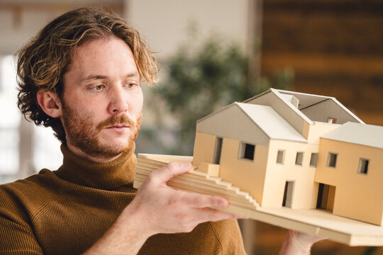 Architect holding house model for building planning and design