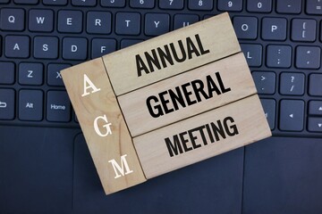 Blocks Displaying AGM Annual General Meeting on a Laptop Keyboard