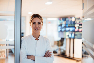 Medical researcher standing in modern clinic surrounded by technology