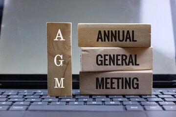Blocks Displaying AGM Annual General Meeting on a Laptop Keyboard