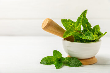 Cucumber water with lemon, lime and mint on a wooden table. Water infused with sliced...