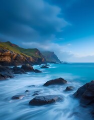 Obraz premium Rocky coastline with waves under blue sky