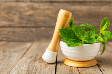 Cucumber water with lemon, lime and mint on a wooden table. Water infused with sliced...