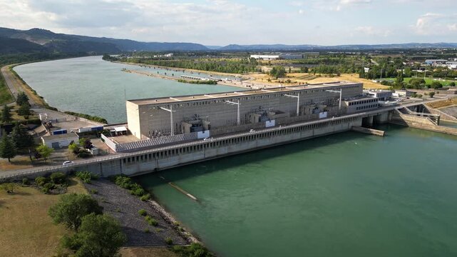 Bourg les Valence, France - 2 August 2025: Drone aerial panorama of CNR hydroelectric power plant on the Rhone River renewable green energy infrastructure with dam water flow turbines.