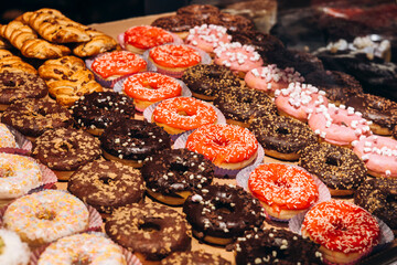 Colorful and appetizing glazed donuts displayed in a bakery shop window.