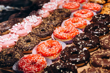 Colorful and appetizing glazed donuts displayed in a bakery shop window.