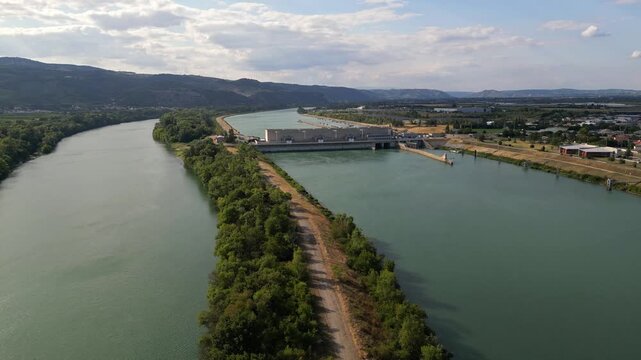 Bourg les Valence, France - 2 August 2025: Drone aerial panorama of CNR hydroelectric power plant on the Rhone River renewable green energy infrastructure with dam water flow turbines.