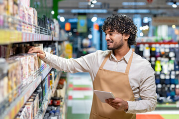 A grocery store employee stocks shelves while using a tablet. The image demonstrates modern retail management, customer service, and the daily responsibilities in a vibrant supermarket setting.