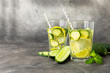 Cucumber water with lemon, lime and mint on a wooden table. Water infused with sliced...