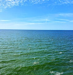 sea and sky.  North Sea, horizon and blue sky with white clouds in summer clear weather.