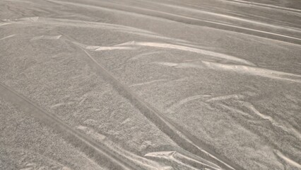 Clear plastic covering the gray carpet. Plastic covering the floor to prevent scratches. Clear plastic to prevent damage. Plastic surface with gray carpet. Texture and background.