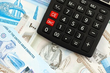 United Arab Emirates dirham currency money bills and calculator. The concept of taxation and money...