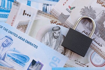 United Arab Emirates dirham currency money bills and padlock. The concept of sanctions and...