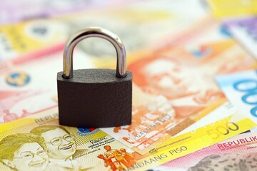 Philippines peso currency money bills and padlock. The concept of sanctions and financial safety