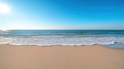 Fototapeta premium Bright beach scene with gentle waves lapping at shore under clear blue sky