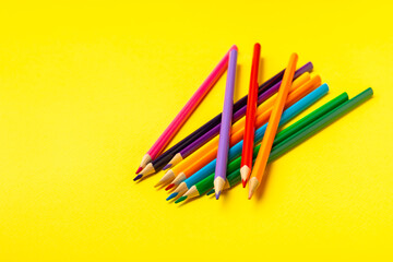 Colored pencils on a bright colored background. Equipment for coloring. Stationery for...