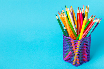 Colored pencils on a bright colored background. Equipment for coloring. Stationery for...
