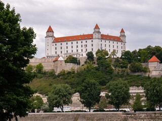 Fototapeta premium Hilltop castle with red roofs and white walls, ideal for illustrating history, heritage, and travel concepts.