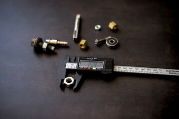 Digital caliper and tools for hand work on dark background