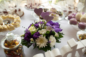 Wedding candy table with purple bouquet centerpiece