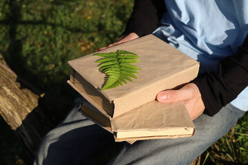 teenager in blue t-shirt and jeans with book in nature in mountains
