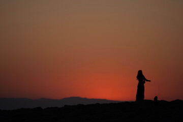 Obraz premium Silhouette of a Woman and Cat at Sunset
