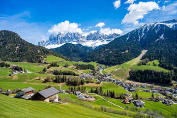 Traditional houses, and the iconic santa maddalena church create a picturesque scene with the odle...