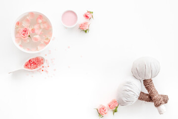 Roses essence water in bowl with petals and skin care cosmetic products with flowers essential oil