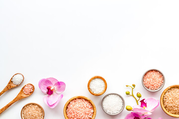Beauty spa therapy cosmetics and wellness flat lay - sea salt in many bowls with flowers, top view