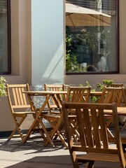 Outdoor Cafe Seating with Wooden Chairs and Tables in Sunlight