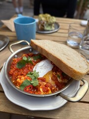 Shakshuka with Poached Egg and Bread Slice in Skillet