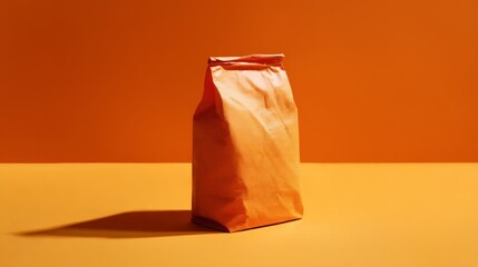 Orange paper bag standing upright on vibrant orange background for packaging concept