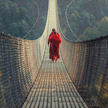 Fototapeta Suspension bridge in Nepal near Pokhara with a monk.