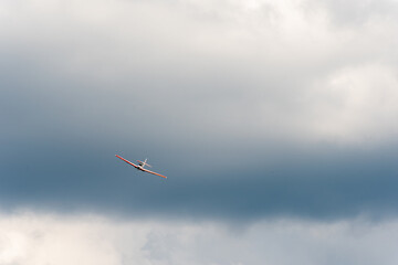 Airplane banking in cloudy sky with dramatic background