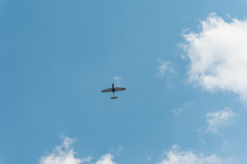 Airplane flying overhead against blue sky with scattered clouds
