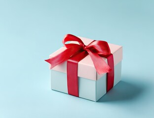 Obraz premium A light pastel blue gift box with a pink top and a vibrant red ribbon bow sits on a light pastel blue background