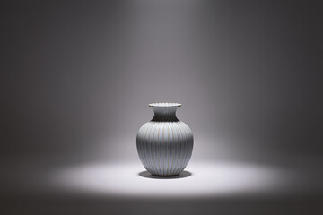 Elegant white ceramic vase illuminated by a single spotlight on a textured gray background