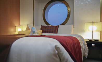 View into oceanview panoramic window porthole cabin stateroom in cozy Italian interior design...