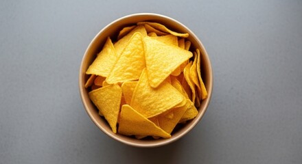Bowl of triangular, yellow tortilla chips viewed from directly above