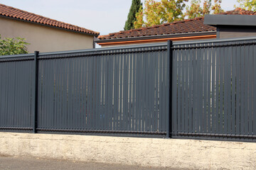 Clôture gris anthracite, en lattes PVC rigide sur muret