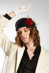 Elegant young man expresses fashion with unique accessories and confident pose in a creative studio