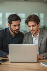Obraz premium Two young businessmen discuss business problems in warehouse using laptop.