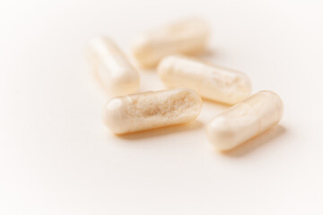 Coenzyme Q10 capsules. Antioxidants. Concept for a healthy dietary supplementation. Bright paper background. Soft focus. Close up. Copy space.	