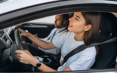 Looking for a way, driving. Woman is with instructor in car, driving school concept