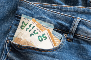 Pants pocket in jeans with money, much bills. Business concept.